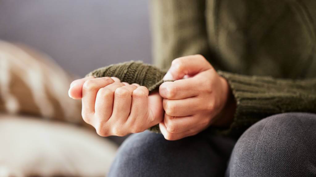 Person holding their hands, representing the struggle of living with an anxiety disorder.