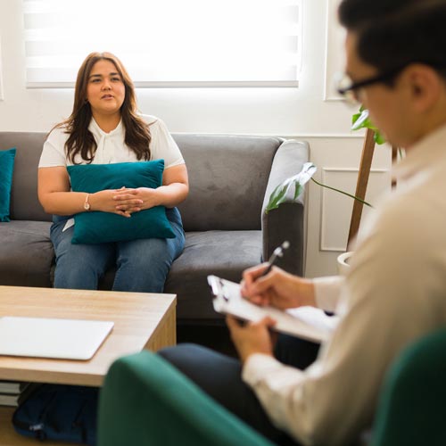 Woman sitting and talking to a meantal health coach